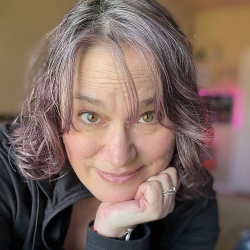 A photo of author Lani Diane Rich with pinkish-purple dyed hair 