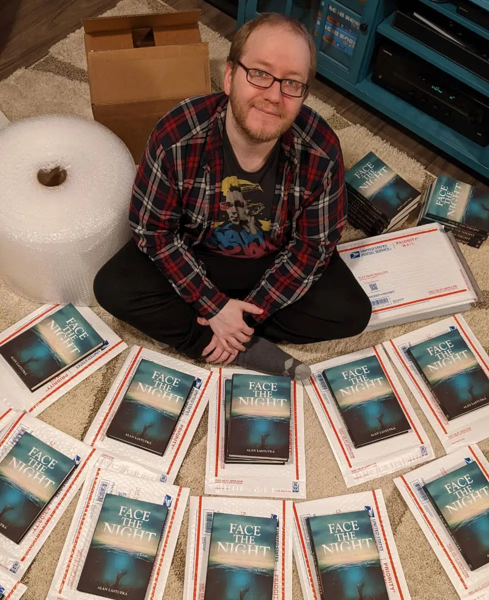 Alan Lastufka surrounded by copies of Shortwave’s first title, Face the Night.