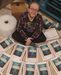 Alan Lastufka surrounded by copies of Shortwave’s first title, Face the Night.